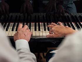 zwei Hände auf einem Klavier