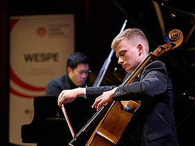 Junger Musiker auf Bühne musizierend
