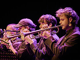 Musiker Blasinstrumente spielend, seitlich aufgenommen