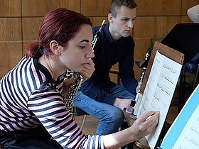 European Workshop for Contemporary Music © James Chan-A-Sue Musikerin mit Notenständer und Noten schreibend
