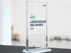 Plakette Landmusik, durchsichtig stehend mit Schriftzug Landmusikort des Jahres 2024