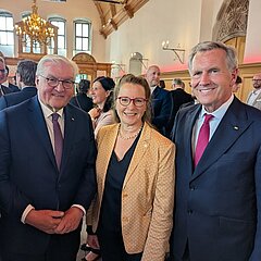 Drei Personen in Kamera lächelnd: Bundespräsident Frank-Walter Steinmeier, Generalsekretärin DMR Antje Valentin und Christian Wulff