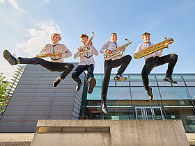 4 Jugendliche in die Luft springend mit ihren Saxofonen in der Hand, Deutscher Musikrat, Jugend musiziert