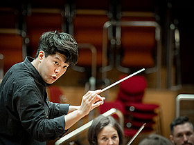 Finalist des German Conducting Award 2021 Dirigent Hangyul Chung mit Dirigierstab vor Orchester