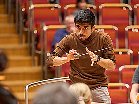 Dayner Tafur-Díaz © Claus Langer Dirigent Dayner Tafur-Díaz Teilnehmer German Conducting Award 2023 mit Dirigierstab vor Orchester, Deutscher Musikrat